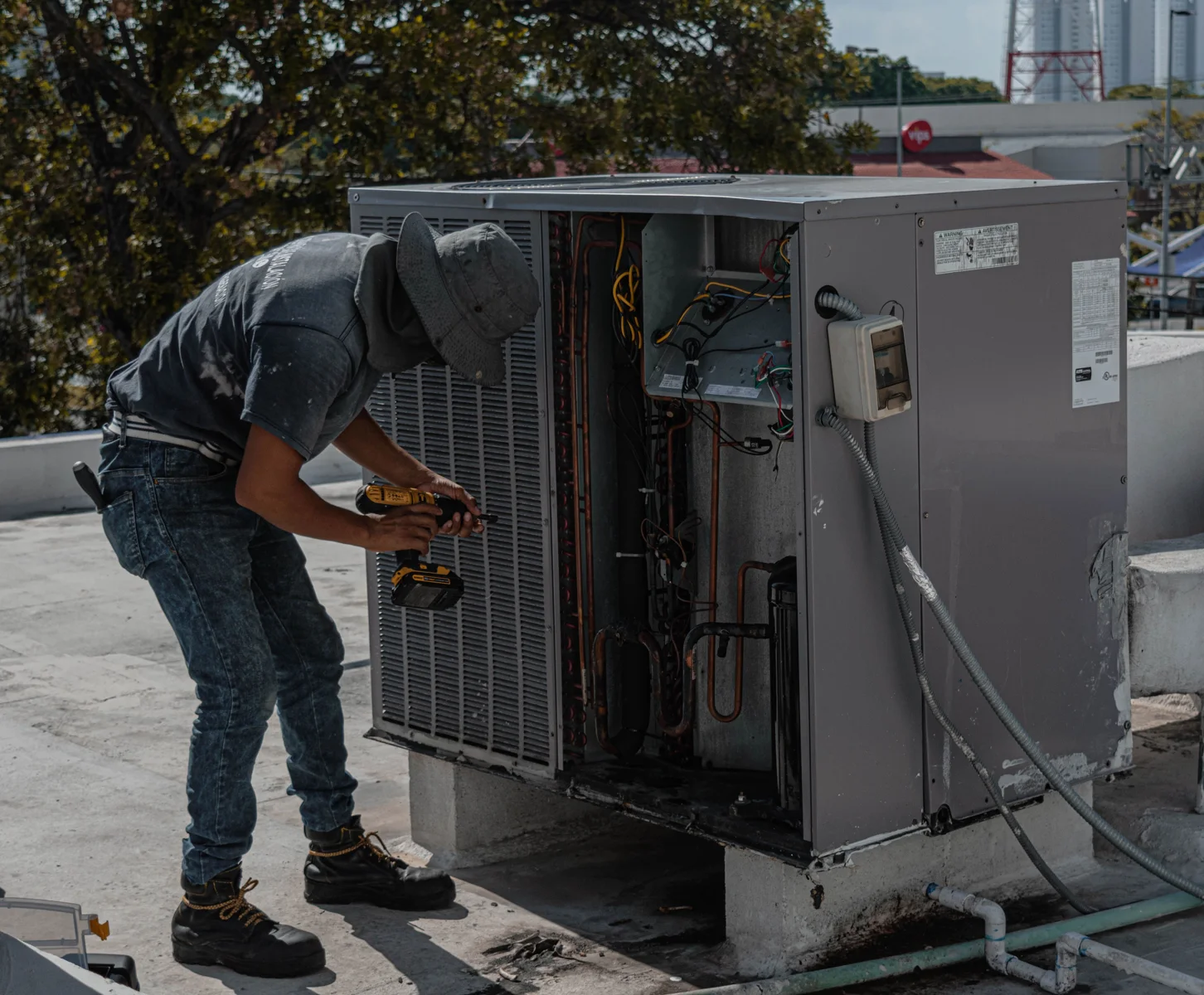 Técnico trabajando en una unidad exterior de aire acondicionado.