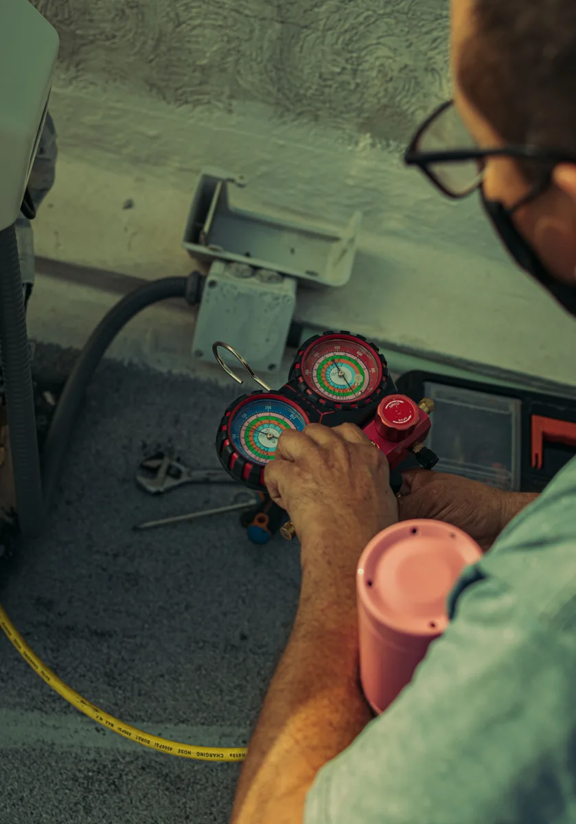 Técnico trabajando en una unidad exterior de aire acondicionado.